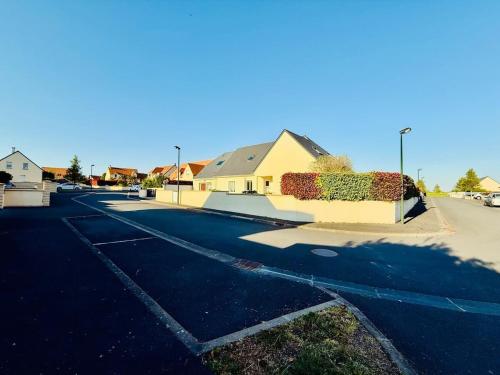 a parking lot with a house and a street at Loft tout confort avec parking et à moins 15 min Caen et des Plages in Démouville