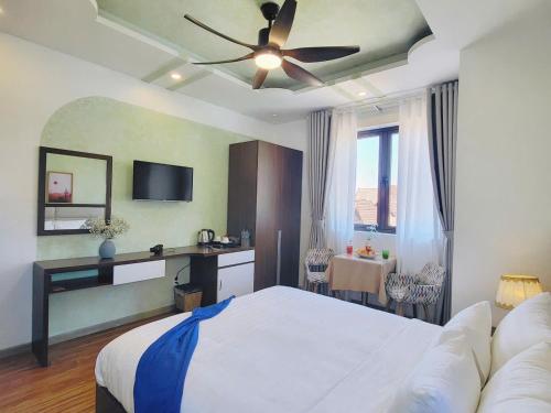 a bedroom with a bed and a ceiling fan at Tasme Dalat Signature in Da Lat