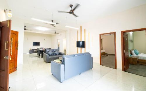 a living room with a blue couch and a living room at Solandis Service Apartment in Manipala