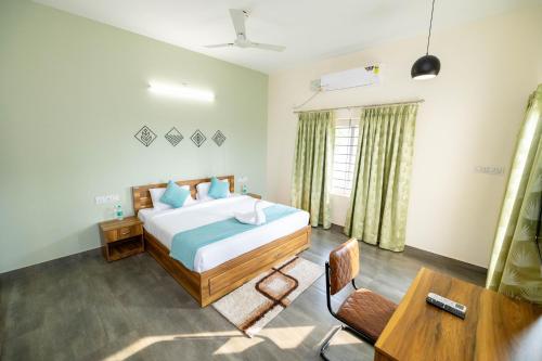 a bedroom with a bed and a desk and a table at Solandis Service Apartment in Manipala