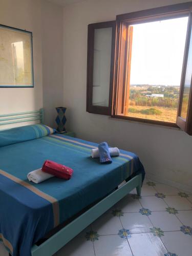 a bedroom with a bed with two towels on it at Villetta Cala Rotonda in Favignana