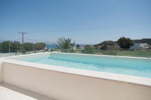 a swimming pool with a view of the ocean at Kathara Bay Apartments in Faliraki