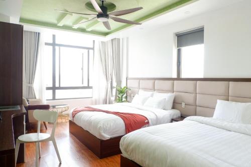 a bedroom with two beds and a ceiling fan at Tasme Dalat Signature in Da Lat