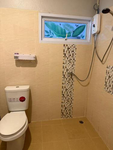 a bathroom with a toilet and a window and a shower at Ler Hostel 65 in Chaweng