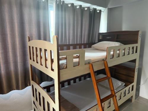 two bunk beds in a room with a window at Ler Hostel 65 in Chaweng