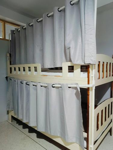 a bunk bed with white curtains in a room at Ler Hostel 65 in Chaweng