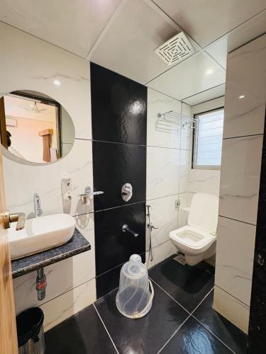 a bathroom with a sink and a toilet at Hotel Airport Palace in Mumbai
