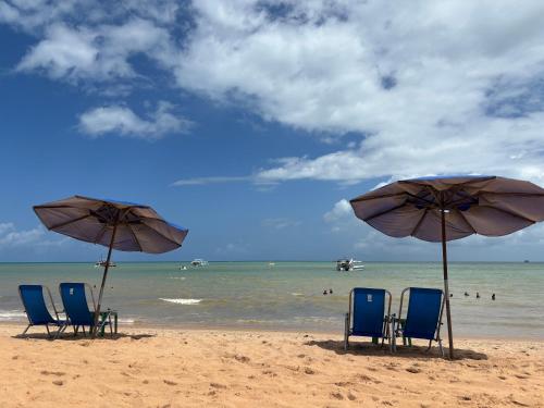un gruppo di sedie e ombrelloni su una spiaggia di Tambaú Israel Flat 217 - Beira mar a João Pessoa