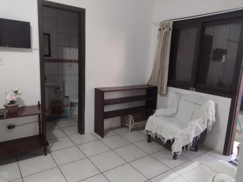 a white room with a bed and a window at Cidreira-Salinas Casinha in Cidreira
