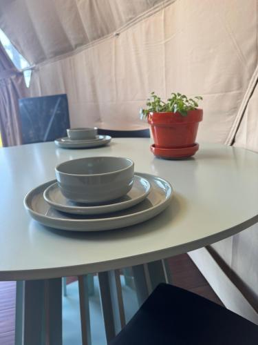 a table with two plates and a potted plant on it at Hanmer Glamping in Hanmer Springs