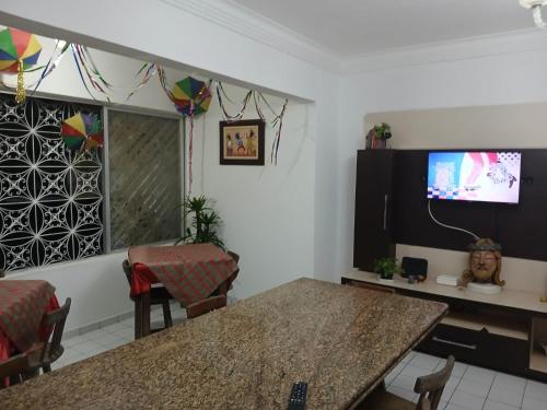 a living room with a table and a tv at Boa Viagem Hostel Pequeno Príncipe in Recife