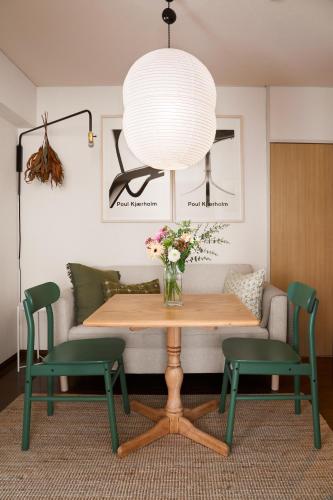 a living room with a table and two green chairs at Holiday Places /SHIBUYA 5min by train (Sangenjaya) in Tokyo