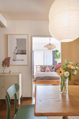 a room with a table with a vase of flowers at Holiday Places /SHIBUYA 5min by train (Sangenjaya) in Tokyo