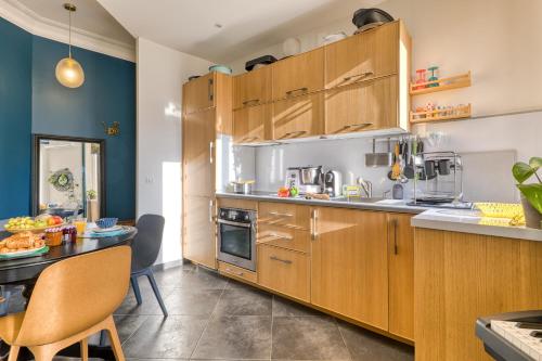 - une cuisine avec des placards en bois et une table à manger dans l'établissement Cocon D'Azur - 5min from the beach - Happy Rentals, à Nice