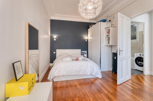 - une chambre avec un lit blanc et un lustre dans l'établissement Cocon D'Azur - 5min from the beach - Happy Rentals, à Nice