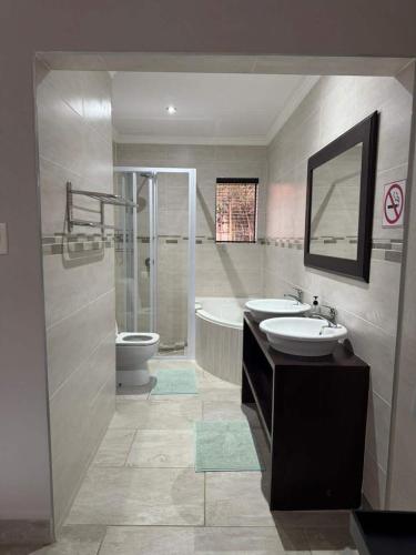 a bathroom with a sink and a tub and a toilet at Seepraal luxury accommodation in Jeffreys Bay