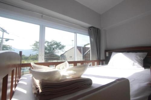 a bedroom with a bed and a large window at Ler Hostel 65 in Chaweng