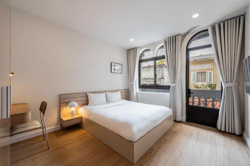 una camera da letto con un letto bianco e una finestra di Home by CR Concept in Center City ad Ho Chi Minh