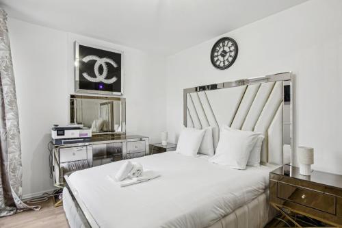 - une chambre dotée d'un lit avec une horloge murale dans l'établissement Le Havre de Paix, à Bezons