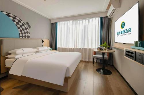 a bedroom with a large white bed and a tv at City Comfort Inn Nanning Guangxi University in Nanning