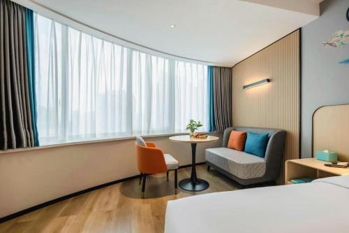 a hotel room with a bed and a table and a chair at City Comfort Inn Nanning Guangxi University in Nanning