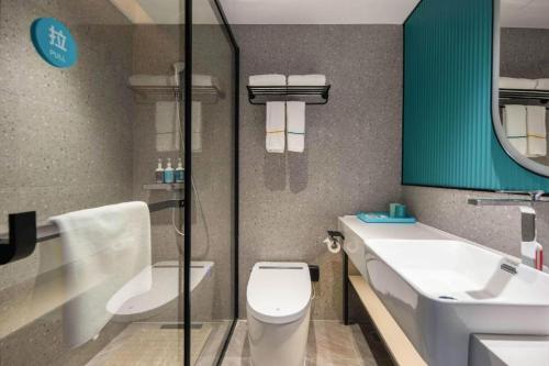 a bathroom with a toilet and a sink and a mirror at City Comfort Inn Nanning Guangxi University in Nanning