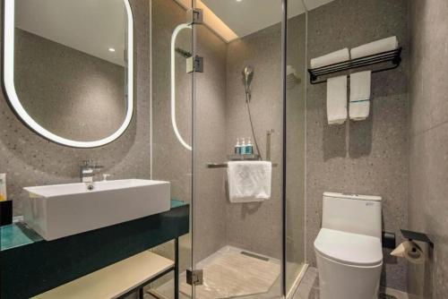 a bathroom with a sink and a toilet and a mirror at City Comfort Inn Nanning Guangxi University in Nanning