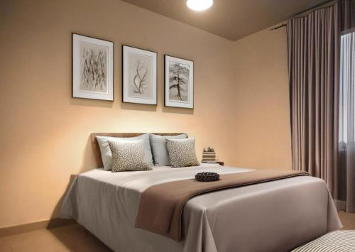 a bedroom with a bed with three pictures on the wall at Villa Spacieuse au Calme Absolu avec Grande Piscine Jacuzzi Chauffé - Grand Jardin Sans Vis a vis- Salle de Jeux avec Fresque du Nougat - Ideal Familles et Groupes Drome Provencale in Montélimar
