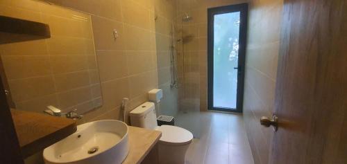 a bathroom with a toilet and a sink and a window at Baisao Villa in Phú Quốc