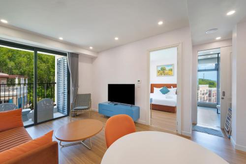 a living room with a couch and a tv and a bed at La isla Apartments & Villas - Sea View & Fireworks Phu Quoc in Phu Quoc