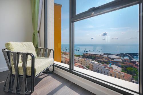 a chair in a room with a large window at La isla Apartments & Villas - Sea View & Fireworks Phu Quoc in Phu Quoc