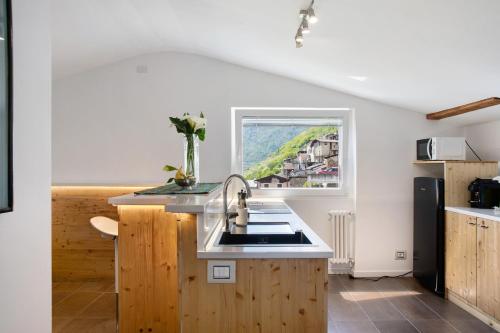 a kitchen with a sink and a window at Mansarda a Ca' Leuscc in Montagna in Valtellina
