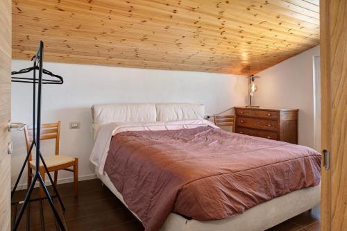 a bedroom with a bed and a wooden ceiling at Mansarda a Ca' Leuscc in Montagna in Valtellina