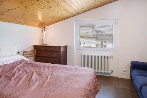 a bedroom with a bed and a window at Mansarda a Ca' Leuscc in Montagna in Valtellina