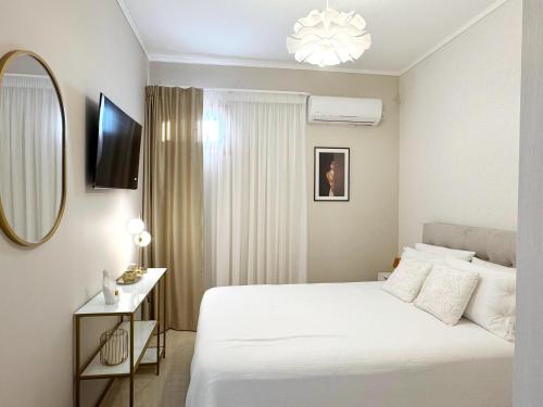 a bedroom with a white bed and a mirror at Bali Bay Luxury Apartment in Balíon