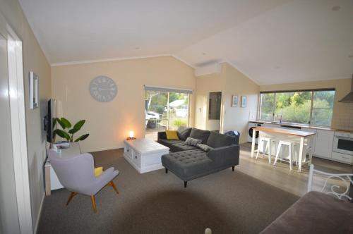 a living room with a couch and a table at Acacia Chalets Margaret River in Margaret River Town