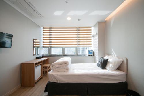 a bedroom with a bed and a desk and a window at K-Guesthouse Dongdaemun Premium in Seoul