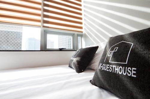 a bed with two pillows on it in front of a window at K-Guesthouse Dongdaemun Premium in Seoul