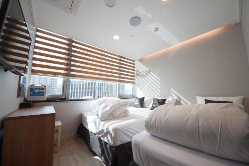 a hotel room with two beds and a window at K-Guesthouse Dongdaemun Premium in Seoul
