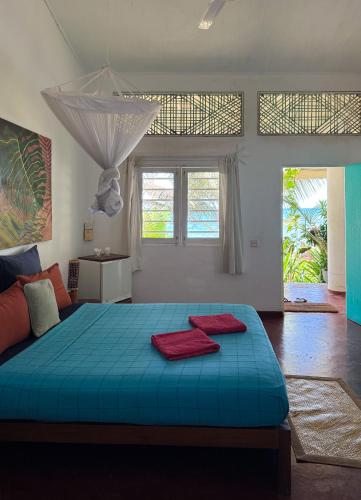 a bedroom with a blue bed with two red pillows on it at Palm villa Mirissa hotel&spa in Mirissa