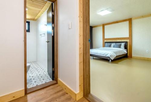 a bedroom with a bed and a mirror at Bada Maru Pension in Seogwipo