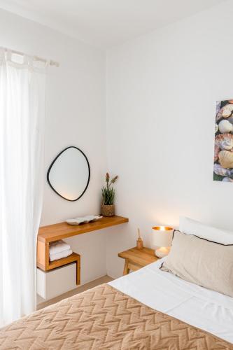 a bedroom with a bed with a mirror and a table at Litsa Malli Rooms in Pollonia