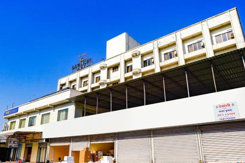 a white building with a sign on top of it at FabHotel Devanshi Inn in Kalamboli