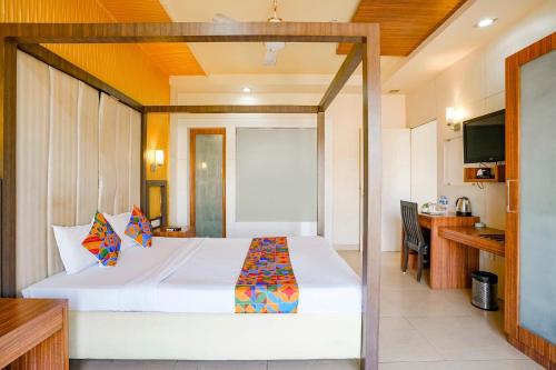a hotel room with a bed and a television at FabHotel Devanshi Inn in Kalamboli