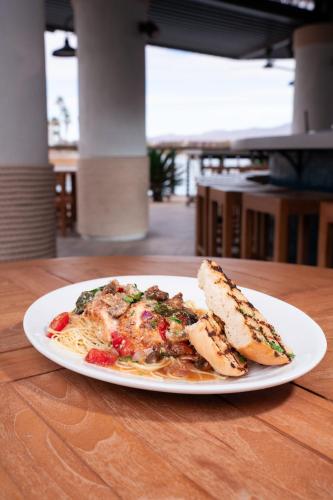 a plate of pasta and a piece of bread on a table at The Nautical Beachfront Resort in Lake Havasu City