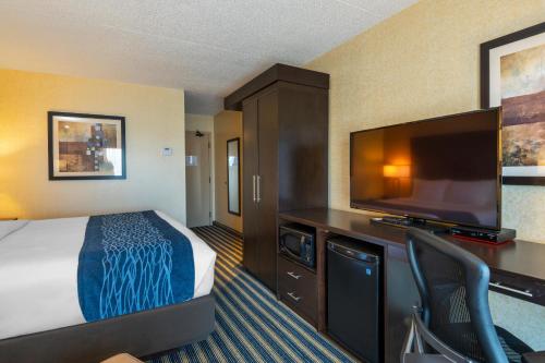 a hotel room with a bed and a flat screen tv at Comfort Inn in Saint Thomas