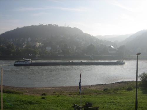 a large boat traveling down a river with a mountain at RheinHotel ARTE in Remagen