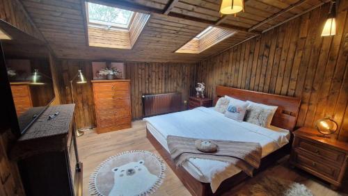 a bedroom with a bed in a wooden room at UMANI Retreat in Buşteni