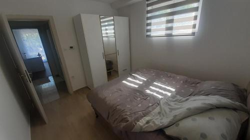 a bedroom with a bed and a window at Apartman EXIT-TVRĐAVA in Petrovaradin
