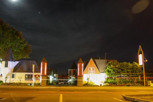 a group of buildings with neon signs at night at Camelot Motor Lodge in Christchurch
